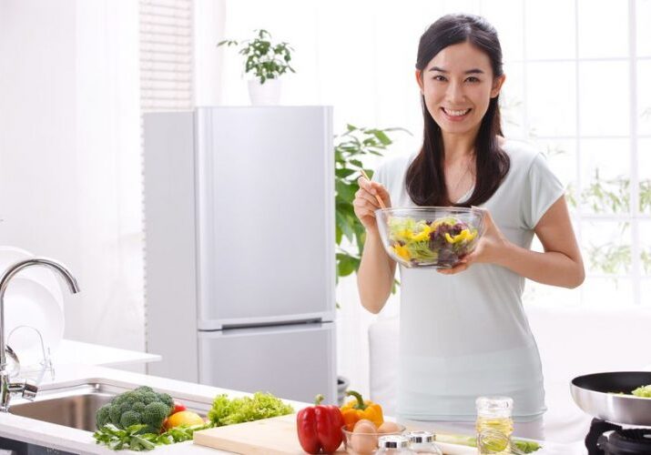 Photo of a woman in a kkitchen preparing vegetables