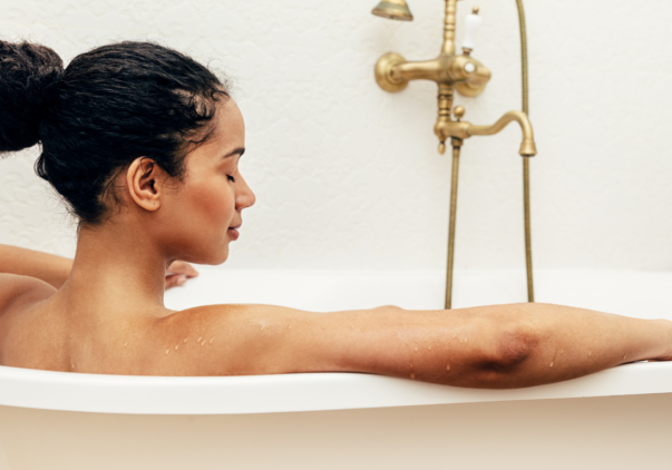 Photo of young relaxed woman soaking in a bath.
